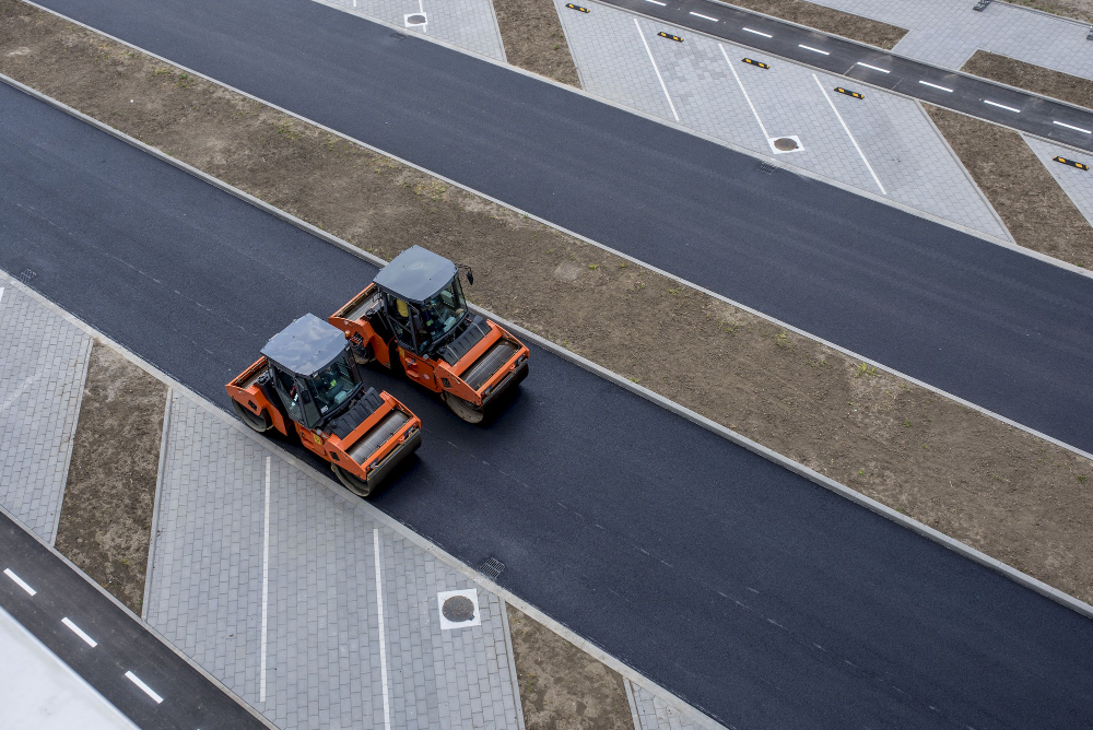 aerial view orange asphalt roller compactor new pavement road resurfacing